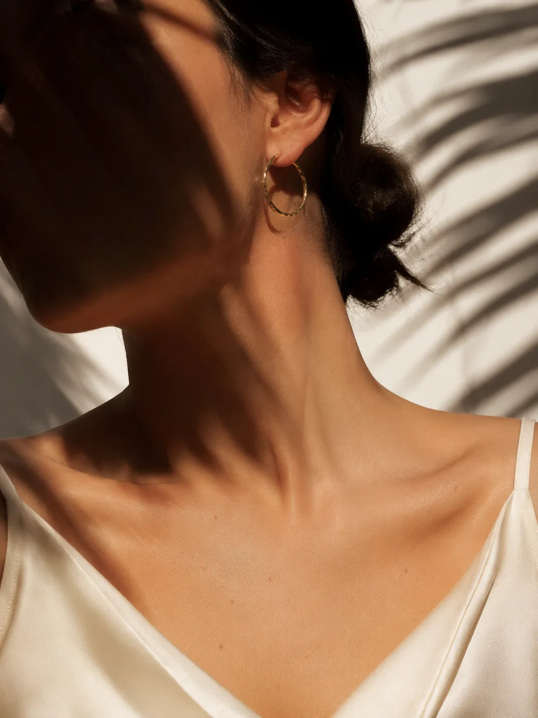 گوشواره حلقه‌ای طلایی با جزئیات تراش روی گوش مدل