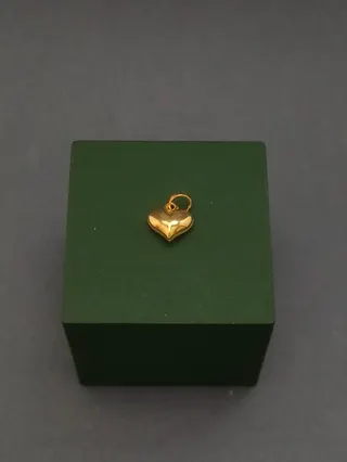 پلاک قلبی طلایی‌رنگ روی جعبه سبز
